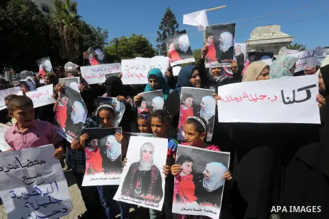 Palestinians hold banners during a protest due to prevent Ms. Jalila Dahlan from entering the Gaza Strip, in Gaza city, on Sept. 28, 2016. Photo by Mohammed Asad