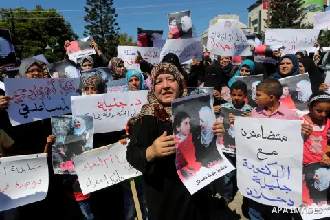 Palestinians hold banners during a protest due to prevent Ms. Jalila Dahlan from entering the Gaza Strip, in Gaza city, on Sept. 28, 2016. Photo by Mohammed Asad