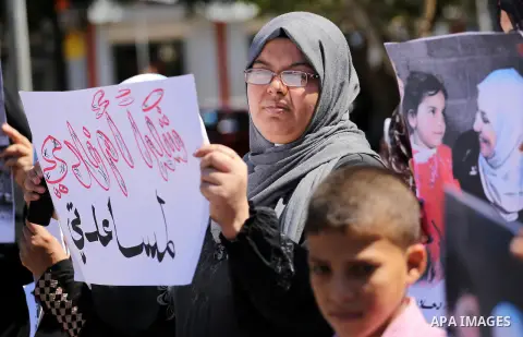 Palestinians hold banners during a protest due to prevent Ms. Jalila Dahlan from entering the Gaza Strip, in Gaza city, on Sept. 28, 2016. Photo by Mohammed Asad