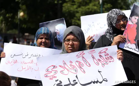 Palestinians hold banners during a protest due to prevent Ms. Jalila Dahlan from entering the Gaza Strip, in Gaza city, on Sept. 28, 2016. Photo by Mohammed Asad