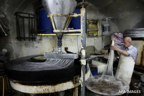 Palestinian Belal al-Zaqa, 64, prepares Kunafa, a traditional and favorite local sweet at his shop, in the West Bank city of Nablus on Sep. 29, 2016. Photo by Nedal Eshtayah