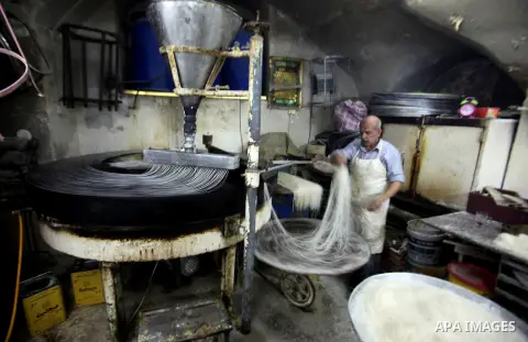 Palestinian Belal al-Zaqa, 64, prepares Kunafa, a traditional and favorite local sweet at his shop, in the West Bank city of Nablus on Sep. 29, 2016. Photo by Nedal Eshtayah