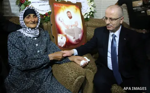 Palestinian Prime Minister Rami Hamdallah visits the mother of Yassir Hamduni who died in Israeli custody following a fatal stroke, in the West Bank city of Jenin on Sep. 29, 2016. Photo by Prime Minister Office