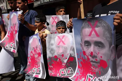 Palestinians hold crossed posters of former Israeli President Shimon Peres, U.S. President Barack Obama and Israeli Prime Minister Benjamin Netanyahu before burning them during a rally following Friday prayers in Gaza Ci...