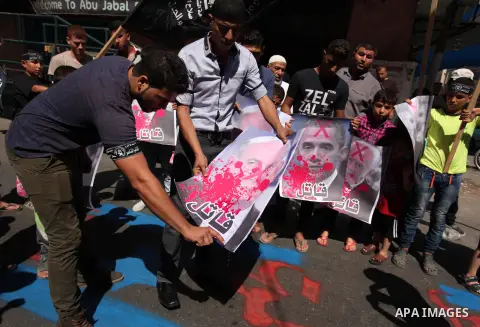 Palestinians burn crossed posters of former Israeli President Shimon Peres, U.S. President Barack Obama and Israeli Prime Minister Benjamin Netanyahu during a rally following Friday prayers in Gaza City September 30, 201...