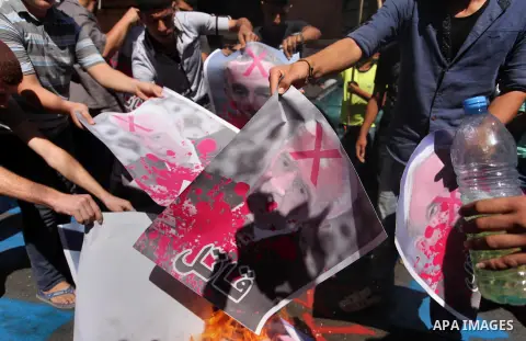 Palestinians burn crossed posters of former Israeli President Shimon Peres, U.S. President Barack Obama and Israeli Prime Minister Benjamin Netanyahu during a rally following Friday prayers in Gaza City September 30, 201...
