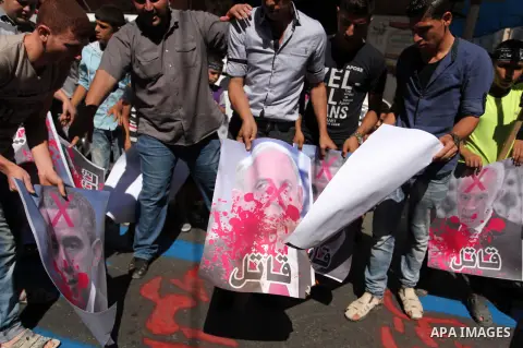 Palestinians burn crossed posters of former Israeli President Shimon Peres, U.S. President Barack Obama and Israeli Prime Minister Benjamin Netanyahu during a rally following Friday prayers in Gaza City September 30, 201...