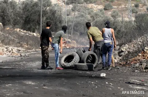 Palestinian protesters burn tires during clashes with Israeli security forces following a weekly demonstration against the expropriation of Palestinian land by Israel on Sep. 30, 2016, in the village of Kfar Qaddum, near...
