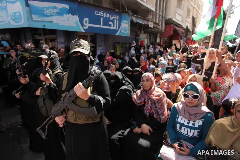 Palestinian women from the Islamic Jihad Movement flash their weapons during a demonstration marking the first anniversary of the so-called Al-Quds uprising in Gaza city, on October 2, 2016. Photo by Ashraf Amra