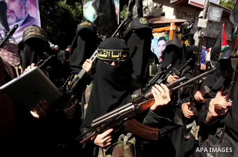 Palestinian women from the Islamic Jihad Movement flash their weapons during a demonstration marking the first anniversary of the so-called Al-Quds uprising in Gaza city, on October 2, 2016. Photo by Ashraf Amra