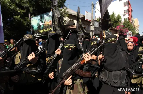 Palestinian women from the Islamic Jihad Movement flash their weapons during a demonstration marking the first anniversary of the so-called Al-Quds uprising in Gaza city, on October 2, 2016. Photo by Ashraf Amra