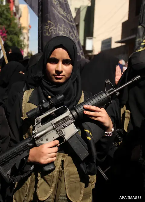Palestinian women from the Islamic Jihad Movement flash their weapons during a demonstration marking the first anniversary of the so-called Al-Quds uprising in Gaza city, on October 2, 2016. Photo by Ashraf Amra