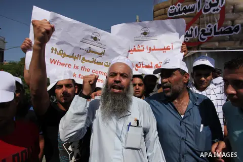 Palestinian owners of factories hold banners during a protest against israeli blockade on operations their factories, in front of the headquarter United Nation "UNSCO", in Gaza city, on October 4, 2016. Photo by Ashraf A...