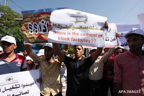 Palestinian owners of factories hold banners during a protest against israeli blockade on operations their factories, in front of the headquarter United Nation "UNSCO", in Gaza city, on October 4, 2016. Photo by Ashraf A...