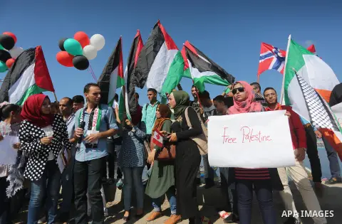 Palestinian youths hold banners during a rally to show solidarity with ship called “Zaytouna” set to arrive in Gaza, at the Seaport of Gaza City October 5, 2016. Photo by Mohammed Asad