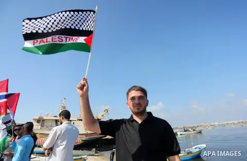 Palestinian youths hold banners during a rally to show solidarity with ship called “Zaytouna” set to arrive in Gaza, at the Seaport of Gaza City October 5, 2016. Photo by Mohammed Asad