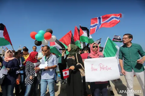 Palestinian youths hold banners during a rally to show solidarity with ship called “Zaytouna” set to arrive in Gaza, at the Seaport of Gaza City October 5, 2016. Photo by Mohammed Asad