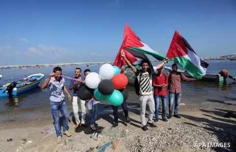 Palestinian youths hold banners during a rally to show solidarity with ship called “Zaytouna” set to arrive in Gaza, at the Seaport of Gaza City October 5, 2016. Photo by Mohammed Asad