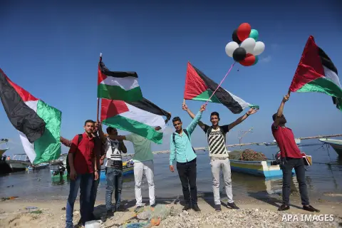 Palestinian youths hold banners during a rally to show solidarity with ship called “Zaytouna” set to arrive in Gaza, at the Seaport of Gaza City October 5, 2016. Photo by Mohammed Asad