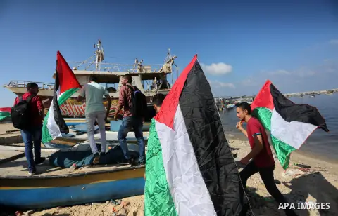 Palestinian youths hold banners during a rally to show solidarity with ship called “Zaytouna” set to arrive in Gaza, at the Seaport of Gaza City October 5, 2016. Photo by Mohammed Asad