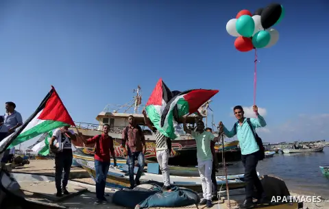 Palestinian youths hold banners during a rally to show solidarity with ship called “Zaytouna” set to arrive in Gaza, at the Seaport of Gaza City October 5, 2016. Photo by Mohammed Asad
