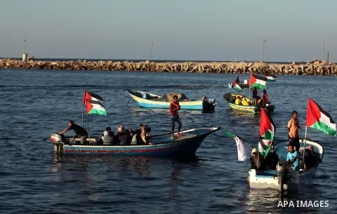Palestinian women sail boats bearing their national flag in the port of Gaza City in support of the Gaza-bound flotilla of international female activists attempting to break the Israeli blockade on Gaza Strip on October...