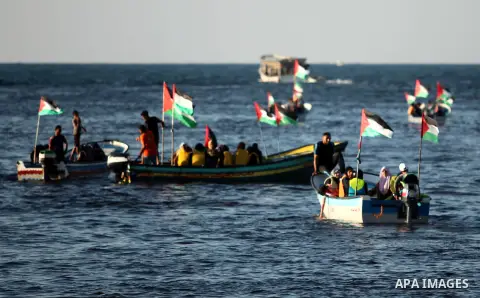 Palestinian women sail boats bearing their national flag in the port of Gaza City in support of the Gaza-bound flotilla of international female activists attempting to break the Israeli blockade on Gaza Strip on October...