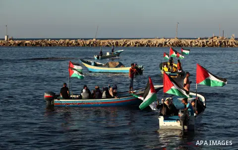 Palestinian women sail boats bearing their national flag in the port of Gaza City in support of the Gaza-bound flotilla of international female activists attempting to break the Israeli blockade on Gaza Strip on October...