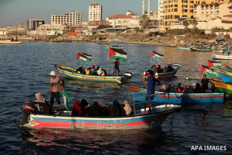 Palestinian women sail boats bearing their national flag in the port of Gaza City in support of the Gaza-bound flotilla of international female activists attempting to break the Israeli blockade on Gaza Strip on October...