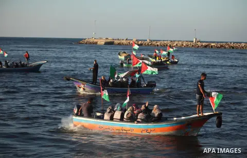 Palestinian women sail boats bearing their national flag in the port of Gaza City in support of the Gaza-bound flotilla of international female activists attempting to break the Israeli blockade on Gaza Strip on October...