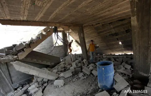 Palestinians inspect the scene of what witnesses said was an Israeli air strike carried out on Wednesday, east of Gaza City October 6, 2016. Photo by Ashraf Amra