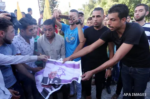 Palestinians who support Palestinian senior Fatah official Mohammed Dahlan burn crossed posters of Palestinian President Mahmoud Abbas and Israeli flags during a protest in Gaza City on Oct. 06, 2016. Photo by Mohammed A...