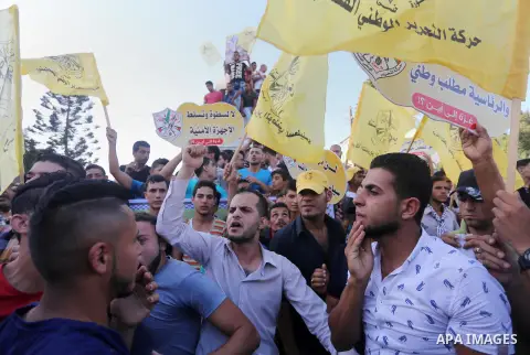 Palestinians who support Palestinian senior Fatah official Mohammed Dahlan, hold banners and national flags during a protest against Palestinian President Mahmoud Abbas in Gaza City on Oct. 06, 2016. Photo by Mohammed As...