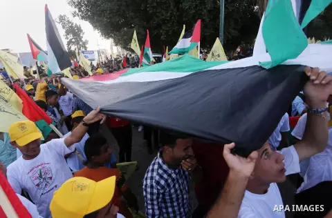 Palestinians who support Palestinian senior Fatah official Mohammed Dahlan, hold banners and national flags during a protest against Palestinian President Mahmoud Abbas in Gaza City on Oct. 06, 2016. Photo by Mohammed As...