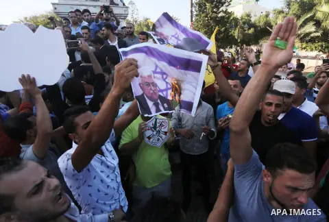 Palestinians who support Palestinian senior Fatah official Mohammed Dahlan burn crossed posters of Palestinian President Mahmoud Abbas and Israeli flags during a protest in Gaza City on Oct. 06, 2016. Photo by Mohammed A...