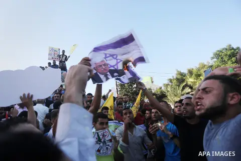 Palestinians who support Palestinian senior Fatah official Mohammed Dahlan burn crossed posters of Palestinian President Mahmoud Abbas and Israeli flags during a protest in Gaza City on Oct. 06, 2016. Photo by Mohammed A...