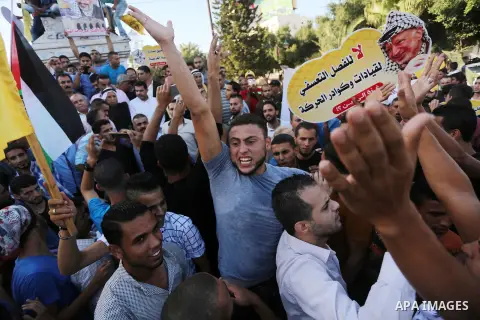 Palestinians who support Palestinian senior Fatah official Mohammed Dahlan, hold banners and national flags during a protest against Palestinian President Mahmoud Abbas in Gaza City on Oct. 06, 2016. Photo by Mohammed As...