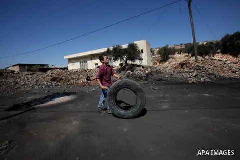 A Palestinian protester burns tires during clashes with Israeli security forces following a weekly demonstration against the expropriation of Palestinian land by Israel on October 6, 2016, in the village of Kfar Qaddum,...