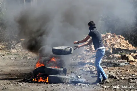 A Palestinian protester burns tires during clashes with Israeli security forces following a weekly demonstration against the expropriation of Palestinian land by Israel on October 6, 2016, in the village of Kfar Qaddum,...
