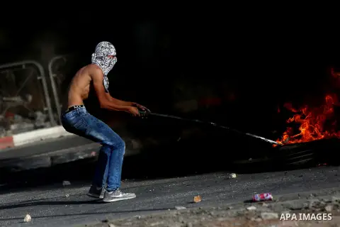 A Palestinian protester burns tires during clashes with Israeli border policemen in the West Bank town of Al-Ram, near Jerusalem October 9, 2016. A Palestinian opened fire from a car in Jerusalem on Sunday and again as I...