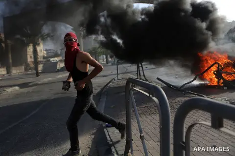 A Palestinian protester hurls stones towards Israeli border policemen during clashes in the West Bank town of Al-Ram, near Jerusalem October 9, 2016. A Palestinian opened fire from a car in Jerusalem on Sunday and again...