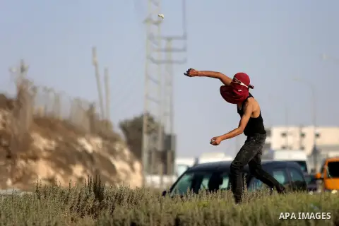 A Palestinian protester hurls stones towards Israeli border policemen during clashes in the West Bank town of Al-Ram, near Jerusalem October 9, 2016. A Palestinian opened fire from a car in Jerusalem on Sunday and again...