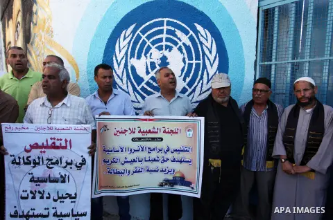 Palestinians hold banners during a protest against the UNRWA decision to reduce of the aid in front of the headquarters United Nations Relief and Works Agency (UNRWA), in Gaza city on October 11, 2016. Photo by Ashraf Am...