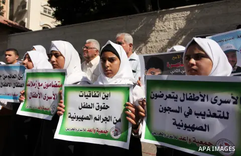Palestinian students hold banners during a protest to show solidarity with the child prisoners in Israeli jails, in front of Red cross office in Gaza city, on October 13, 2016. Photo by Ashraf Amra