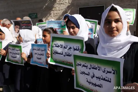 Palestinian students hold banners during a protest to show solidarity with the child prisoners in Israeli jails, in front of Red cross office in Gaza city, on October 13, 2016. Photo by Ashraf Amra