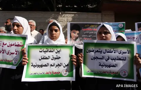 Palestinian students hold banners during a protest to show solidarity with the child prisoners in Israeli jails, in front of Red cross office in Gaza city, on October 13, 2016. Photo by Ashraf Amra