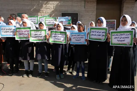 Palestinian students hold banners during a protest to show solidarity with the child prisoners in Israeli jails, in front of Red cross office in Gaza city, on October 13, 2016. Photo by Ashraf Amra
