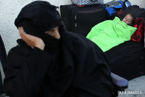 A Palestinian girl sleeps on a suitcase as she waits with her family for a travel permit to cross into Egypt through the Rafah border crossing on October 15, 2016 in the southern Gaza Strip. Egyptian authorities temporar...