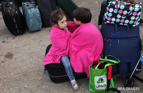 Palestinian chidren sit on a suitcase as they wait with their family for travel permits to cross into Egypt through the Rafah border crossing on October 15, 2016 in the southern Gaza Strip. Egyptian authorities temporari...