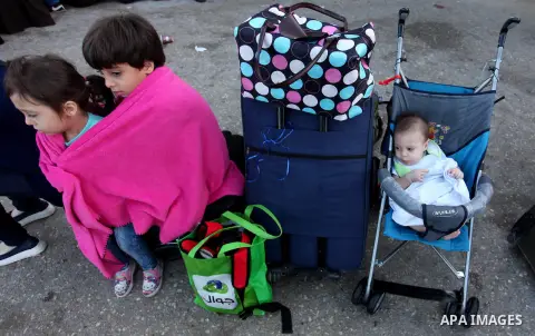 Palestinian chidren sit on a suitcase as they wait with their family for travel permits to cross into Egypt through the Rafah border crossing on October 15, 2016 in the southern Gaza Strip. Egyptian authorities temporari...
